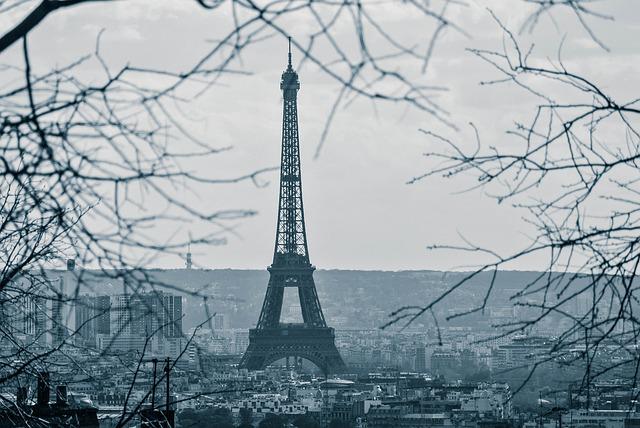 Photo of the Eiffel Tower emerging from grey city blocks in winter.